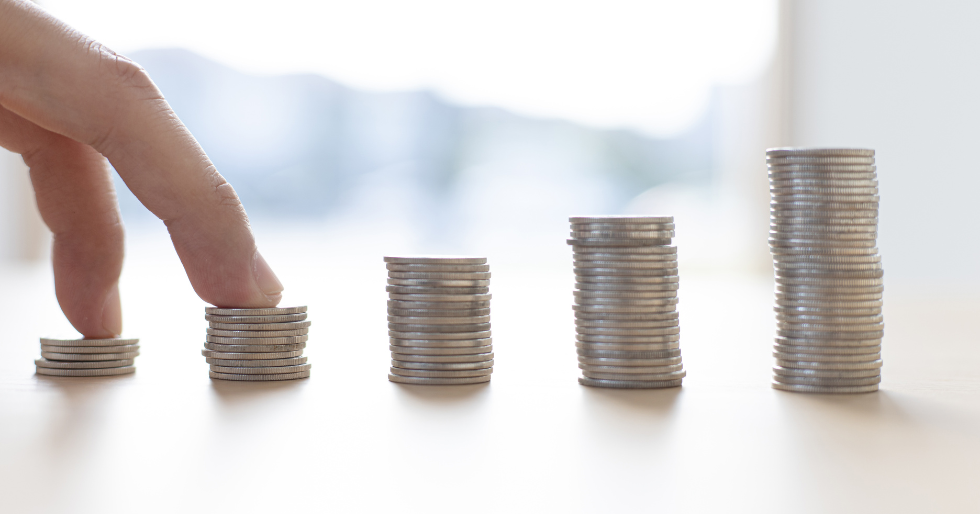 An image illustrating the power of compounding interest with money stacked and he stacks are getting larger as we move from left to right. compounding interest can be capitalized on with traditional and alternative investment types.